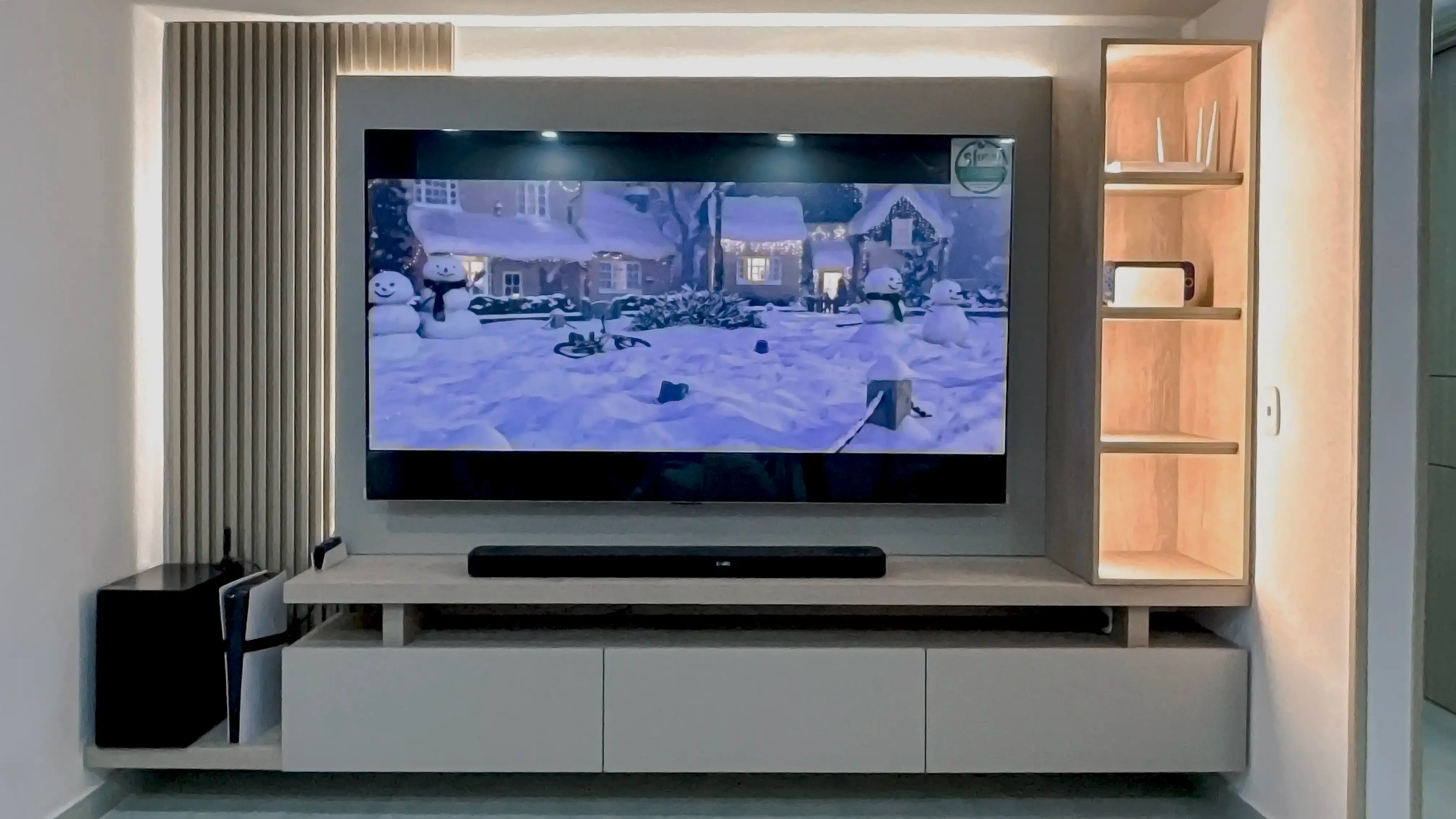 Centro de entretenimiento con pantalla, panel, mueble bajo y repisas